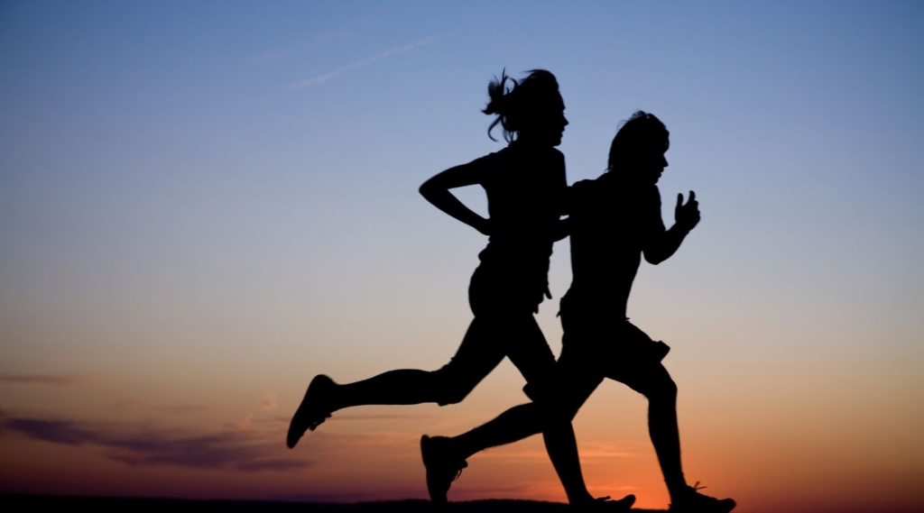 2 people running outdoors against the sunset