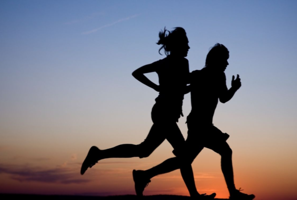 2 people running outdoors against the sunset