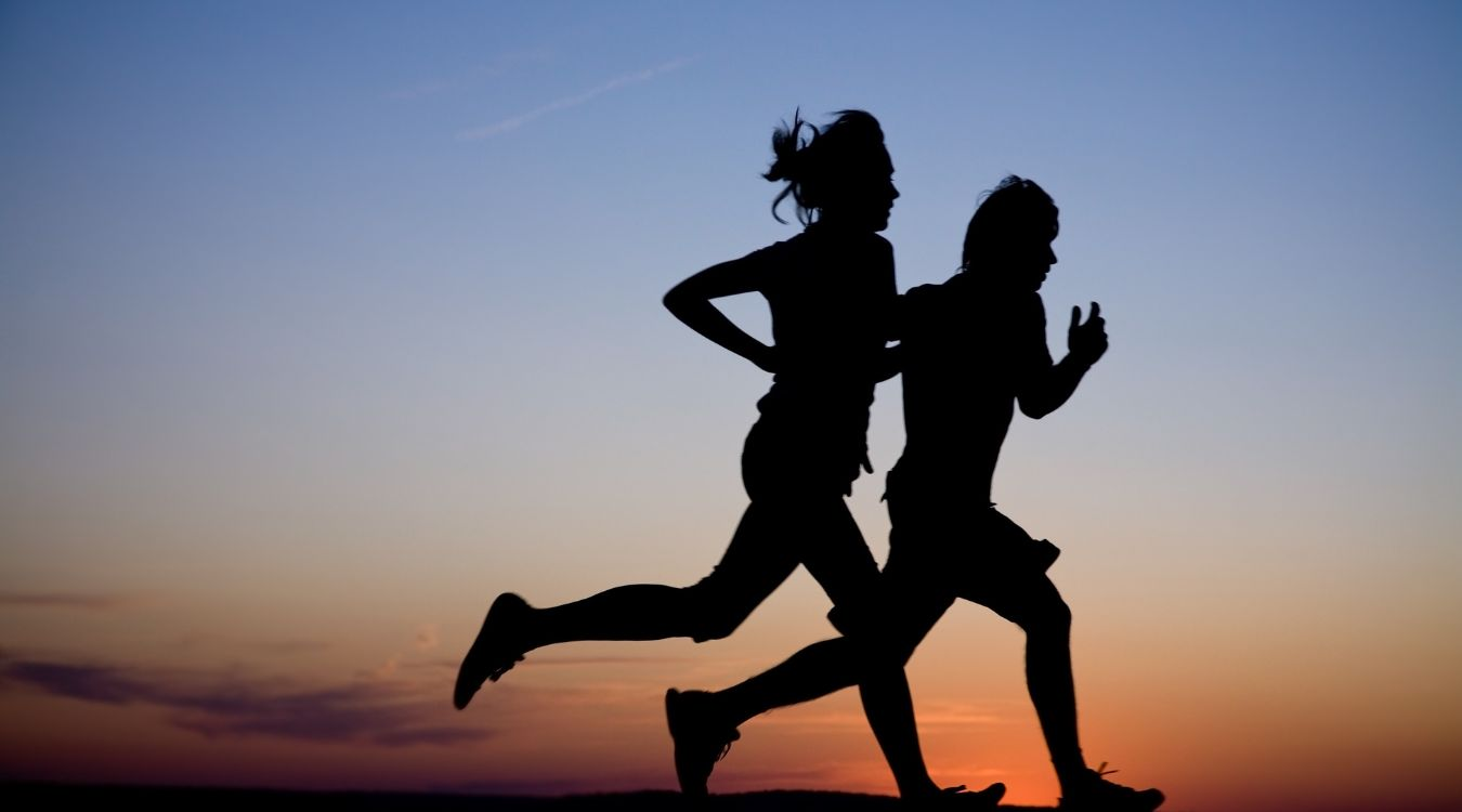 2 people running outdoors against the sunset