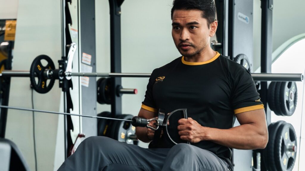 Member training on a resistance machine, illustrating the machine side of the machines versus free weights question